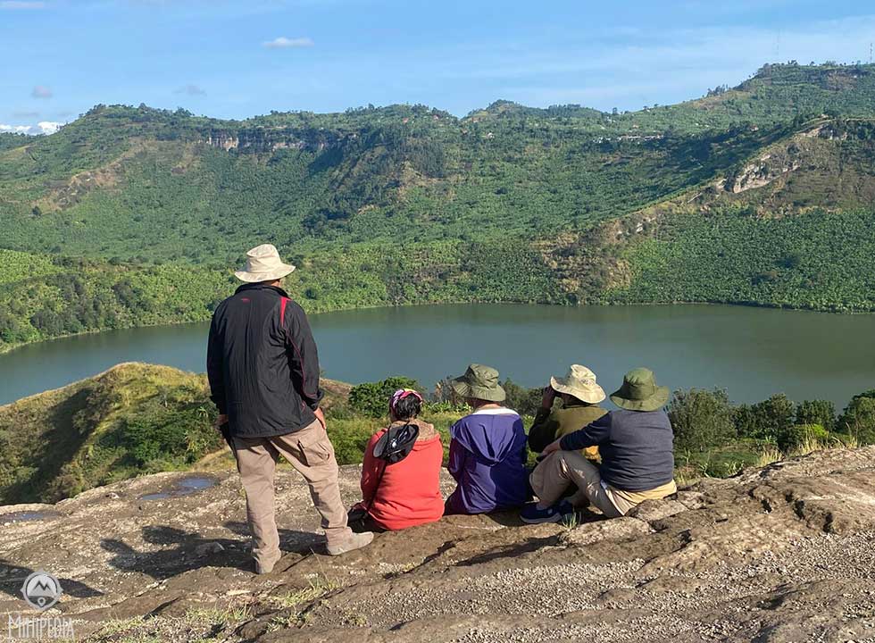 A view of tranquil crater lakes nestled among rolling green hills in Queen Elizabeth National Park