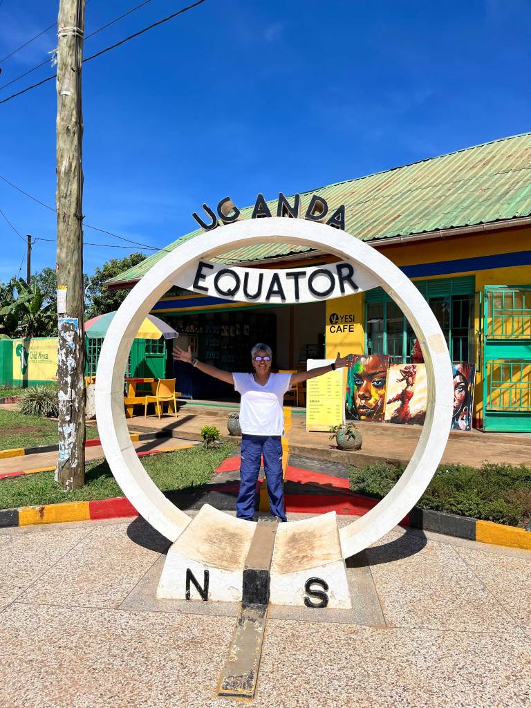 Traveler standing on the Equator line in Uganda