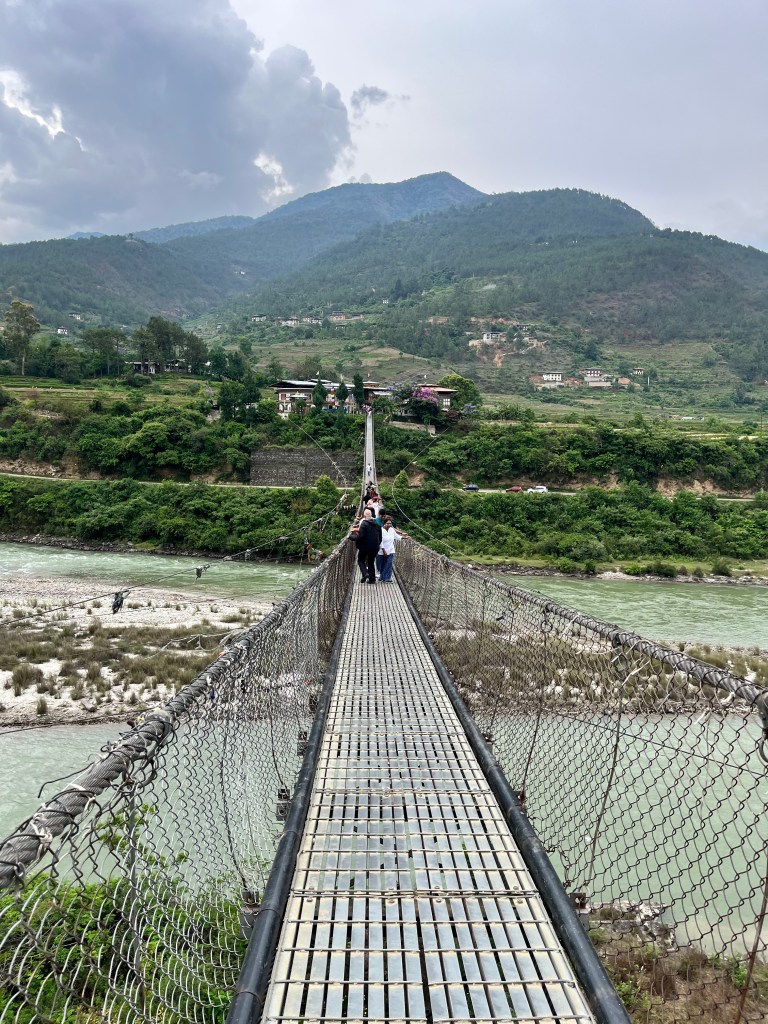 Punakha Suspension Bridge swaying gently above the river with lush green hills in the background